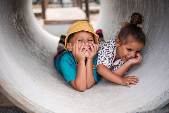 Young First Nations girl and boy playing together in a tunnel