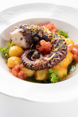 octopus with boiled potatoes and vegetables on a white background