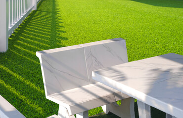 White Outdoor marble Table Set on Green Artificial Turf and white Wooden Picket in Front Yard area...