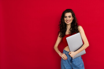 Young girl hold laptop wear trousers isolated over red shine color background