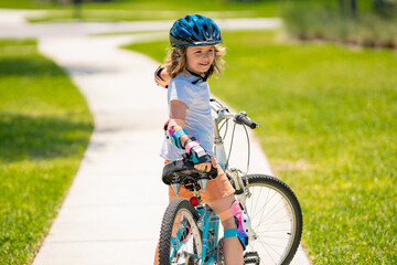 Child on bicycle outdoor. Boy in a helmet riding bike. Little cute adorable caucasian boy in safety...