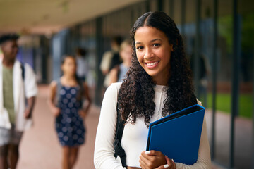 Portrait Of Female Secondary Or High School Student Outdoors At School Walking To Class - obrazy, fototapety, plakaty