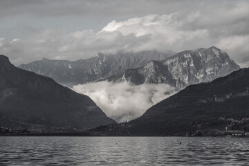 Panoramic scene with clouds, lake and mountains in black and white.