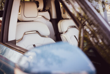 Selective focus through mirror into artificial leather driving seats ergonomics sport design synthetic leather upholstery on new car