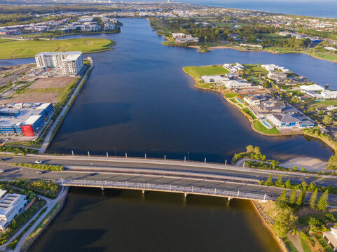 Aerial view of a bridge crossing a canal with real estate developments on ether side