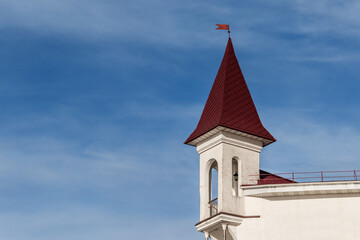 Vintage white tower on building on the background of blue sky. Copy space.