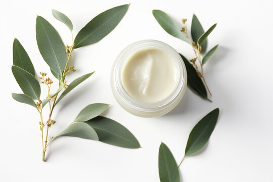 Natural organic cream jar with eucalyptus leaves on white background
