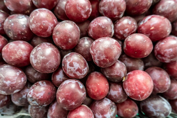 photo of a lot of plums on the counter of the store