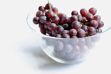 bunch of grapes close up in glass bowl on white background