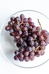 bunch of grapes close up in glass bowl on white background