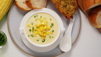 Corn Soup and Bread breakfast menu on white table