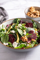Healthy Salad made from Green Salad Leaves, Rocket Salad, Slices of Beetroot, Avocado, pieces of Feta Cheese, Walnuts and Sesame Seeds.