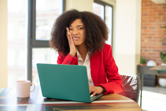pretty afro black woman feeling bored, frustrated and sleepy after a tiresome. businesswoman and laptop concept