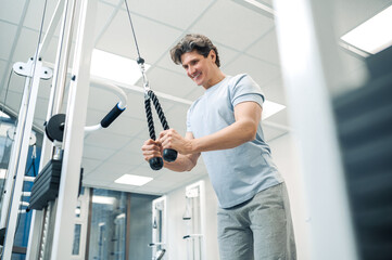 Smiling dark-haired man standing near training device