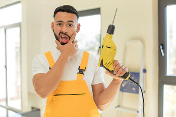 arab handsome man arab man with mouth and eyes wide open and hand on chin. handyman concept