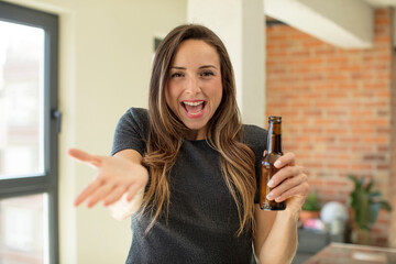 pretty woman smiling happily and offering or showing a concept. beer bottle