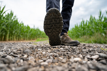 Low angle view of male feet in hiking boots stepping towards camera