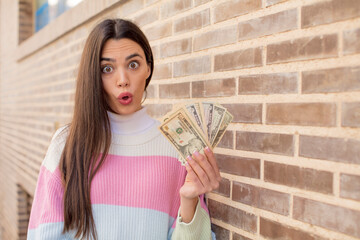 pretty young model feeling extremely shocked and surprised. dollar banknotes concept