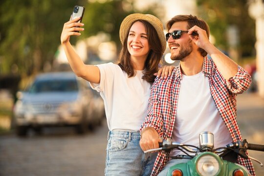 Loving cheerful happy couple taking selfie in the city.
