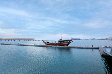 Doha, Qatar - April 25, 2023: Traditional boats called Dhows are anchored in the old Doha port
