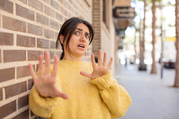 pretty woman feeling terrified, backing off and screaming in horror and panic, reacting to a...