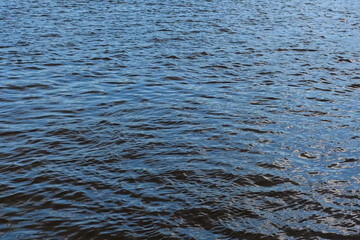Shallow Water surface texture, sunshine natural clear blue water. River water background and sun reflections. Top fly over the sea. Waves on Blue Abstract Seamless with small ripples on a sunny day
