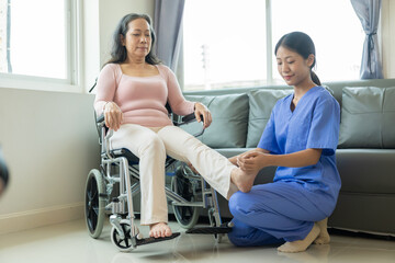 Obraz premium Happy senior woman exercising at home with muscle physiotherapist Retired elderly woman stretching arms and legs at home with personal trainer