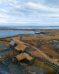 Aerial view of traditional antique Viking village. Old wooden houses near Vestrahorn mountains on the Stokksnes Peninsula, Hofn, Iceland. Popular tourist attraction.
