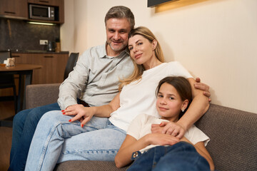Young family sitting on couch in kitchen
