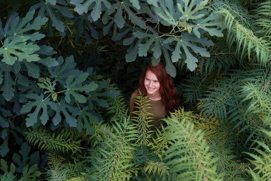 Smiling girl standing amidst plants in nature