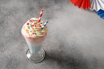 Patriotic milkshake for Independence Day in red, white and blue colors on gray background. Food and refreshing treats for 4th of July or Memorial Day. Close up. Copy space.