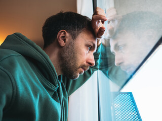 Midlife crisis in men concept. Tired depressed man portrait looking at window with frustrated eyes....