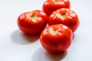 bunch of red tomatoes close up on white background