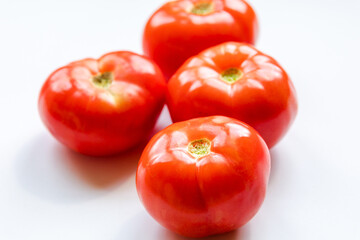 bunch of red tomatoes close up on white background