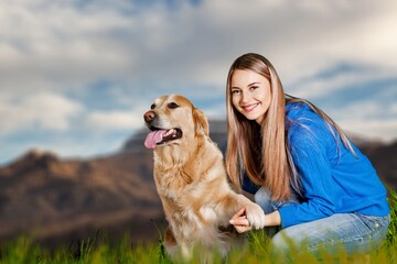 Happy beautiful young woman with cute dog at mountain
