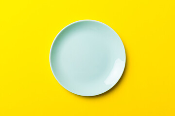 Top view of isolated of colored background empty round blue plate for food. Empty dish with space for your design