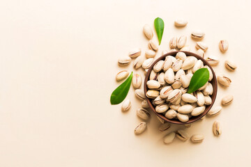 Fresh healthy Pistachios in bowl on colored table background. Top view Healthy eating concept. Super foods