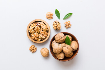 Walnut kernel halves, in a wooden bowl. Close-up, from above on colored background. Healthy eating...