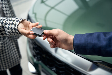 Woman takes the car keys from man in business suit