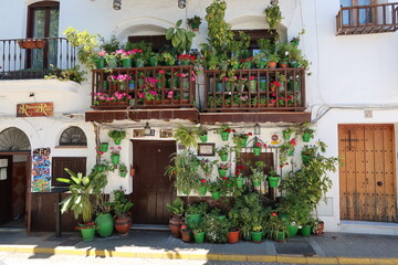 Fototapeta na wymiar Fuenteheridos, Huelva, Spain, April 26, 2023: House with numerous plants in the square of Fuenteheridos, Huelva, Spain