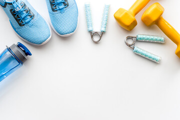 Naklejka premium Sport fitness background with sneakers and dumbbells, top view