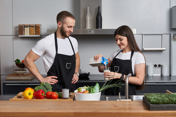 Young couple coocking salad in the kitchen