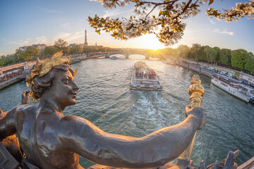 Fototapeta na wymiar Alexandre III bridge in Paris against Eiffel Tower with boat on Seine, France