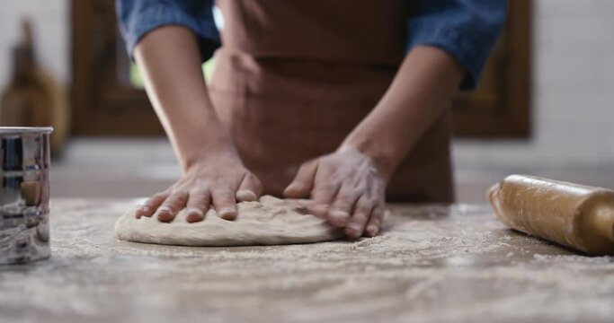 Woman hands kneading dough in the kitchen