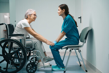 Fototapeta na wymiar Gray-haired woman siting in a wheelchair in clinic