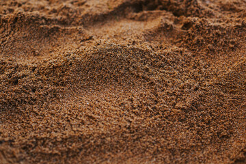 The texture of the sand close-up. Setting sun on the sand on the beach