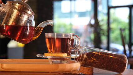 herbal tea in a glass cup brewed in a transparent teapot