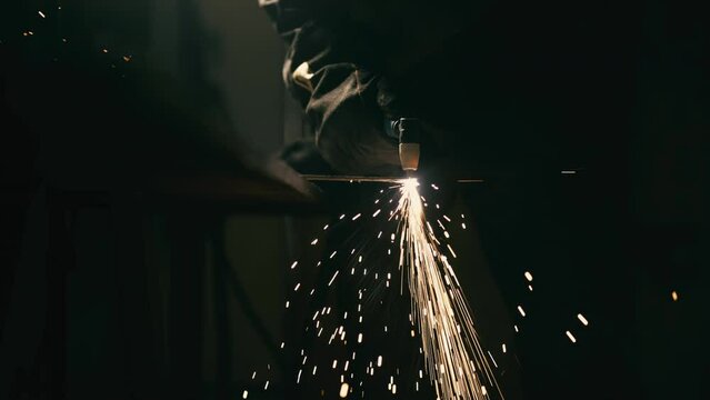 Slow motion: laser cutting, working with a metal workpiece with sparks in a factory. Metalworking, machining, industry, equipment, technology, production concept