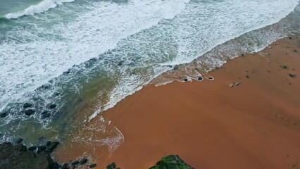 Aerial view green woodland hills sandy beach. Foaming ocean surf at cloudy day