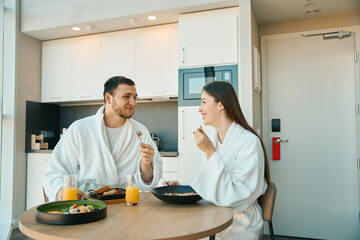 Beautiful young couple has breakfast in a cozy environment